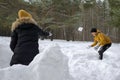 Mom, son and dad are playing snowball fight in winter forest. Family weekend. Royalty Free Stock Photo