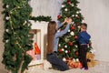 Mom with son decorate Christmas tree new year gifts Garland lights Royalty Free Stock Photo