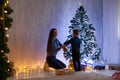 Mom with son decorate Christmas tree new year gifts Garland lights Royalty Free Stock Photo