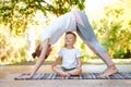 Mom and son do yoga in a summer park. Healthy lifestyle. Royalty Free Stock Photo