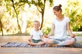 Mom and son do yoga in a summer park. Healthy lifestyle. Royalty Free Stock Photo