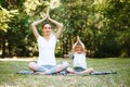 Mom and son do yoga in a summer park. Healthy lifestyle. Royalty Free Stock Photo