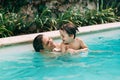 Mom an son get fun into the water in a swimming pool Royalty Free Stock Photo