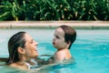 Mom an son get fun into the water in a swimming pool Royalty Free Stock Photo