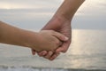 Mom and son kid hands over sunset sea background,family love relationship Royalty Free Stock Photo