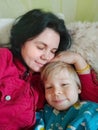 Mom and son lie on the bed, hugging each other and kissing. Mother with her son are having fun lying on top of each Royalty Free Stock Photo