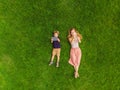 Mom and son are lying on the grass in the park. Mom looks at the phone, son looks at the tablet. Photos from the drone Royalty Free Stock Photo