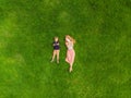 Mom and son are lying on the grass in the park. Mom looks at the phone, son looks at the tablet. Photos from the drone Royalty Free Stock Photo