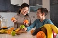 Mom and son making juice from fresh fruit in the kitchen Royalty Free Stock Photo