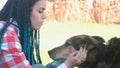 Mom and son pet the dog outside. Close-up faces.