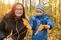 Mom with son play with autumn leaves