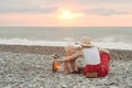 Mom and son play on the pebble beach. Sunset time. Back view Royalty Free Stock Photo