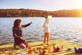 Mom and son playing with paper boats by the lake Royalty Free Stock Photo