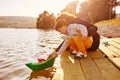 Mom and son playing with paper boats by the lake Royalty Free Stock Photo