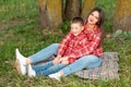 Mom and son, reclining on the bedspread, hug and smile