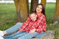 Mom and son, reclining on the bedspread, hug and smile