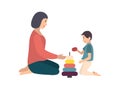 Mom and son sitting on floor and building pyramid together. Mother teaching her little boy to play with toy. Funny Royalty Free Stock Photo