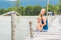 Mom and son are sitting on the old pier and enjoying the sea Royalty Free Stock Photo