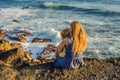 Mom and son are sitting on a rock and looking at the sea. Portrait travel tourists - mom with kids. Positive human Royalty Free Stock Photo