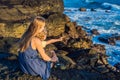 Mom and son are sitting on a rock and looking at the sea. Portrait travel tourists - mom with kids. Positive human Royalty Free Stock Photo