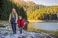 Mom and son tourists in background of Panoramic morning view of Black Lake Crno Jezero. Calm summer scene of Durmitor Royalty Free Stock Photo