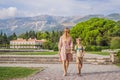 Mom and son tourists walking together in Montenegro. Panoramic summer landscape of the beautiful green Royal park Royalty Free Stock Photo