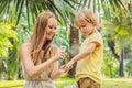 Mom and son use mosquito spray.Spraying insect repellent on skin outdoor Royalty Free Stock Photo