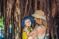 Mom and son on Vietnam travelers are on the background Beautiful tree with aerial roots