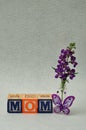 Mom spelled with alphabet blocks and small purple flowers Royalty Free Stock Photo