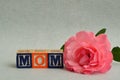 Mom spelled with colorful alphabet blocks and a pink rose Royalty Free Stock Photo