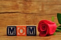 Mom spelled with colorful alphabet blocks and a red rose Royalty Free Stock Photo