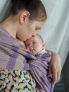 Mom is standing with a baby sleeping in a sling Royalty Free Stock Photo