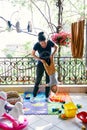 Mom stands on the rug on the balcony and rocks the little child upside down