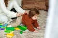 Little toddler girl, crawling and playing with educational toys on rug at home Royalty Free Stock Photo