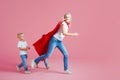 Mom is a superhero. Fun family, a young blond woman in a red Cape and her son. Sons follow mom Royalty Free Stock Photo