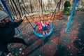 Mom swing her daughter on a swing in the autumn park Royalty Free Stock Photo