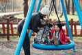 Mom swing her daughter on a swing in the autumn park Royalty Free Stock Photo