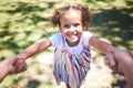 Mom swing me again please. a young girl being swung by her hands in the park. Royalty Free Stock Photo