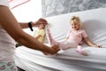 Mom takes off her little daughter`s socks and tickles her feet a little. The girl laughs Royalty Free Stock Photo