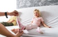 Mom takes off her little daughter`s socks and tickles her feet a little. The girl laughs Royalty Free Stock Photo