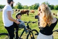 Mom taking a picture of their jolly baby son enjoying a ride with his father