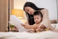 A mom is talking on the phone and working on documents while taking care of her little son Royalty Free Stock Photo