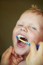 Mom teaches and helps her three-year-old son to brush his teeth Royalty Free Stock Photo
