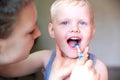 Mom teaches and helps her three-year-old son to brush his teeth Royalty Free Stock Photo