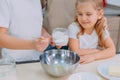 Mom teaches her daughters to cook dough in the kitchen