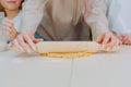 Mom teaches her daughters to cook dough in the kitchen