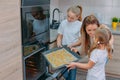 Mom teaches her daughters to cook in the kitchen. The family bakes cookies in the oven Royalty Free Stock Photo