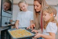 Mom teaches her daughters to cook in the kitchen. The family bakes cookies in the oven Royalty Free Stock Photo