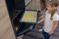 Mom teaches her daughters to cook in the kitchen. The family bakes cookies in the oven