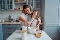 Mom teaches her little daughter to cook food